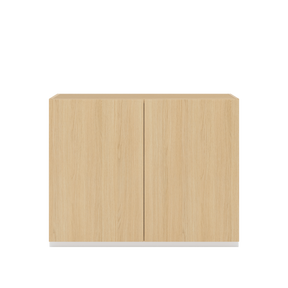 Vor weißem Hintergrund sieht man ein Sideboard aus Eichenholz. Die beiden Drehtüren haben keine Griffe und sind mit einem Push-to-open-Mechanismus ausgestattet.