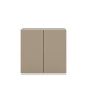 Vor weißem Hintergrund befindet sich ein steingraues Sideboard. Die beiden Drehtüren haben keine Griffe und sind mit einem Push-to-open-Mechanismus ausgestattet.