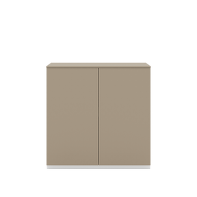 Vor weißem Hintergrund sieht man ein steingraues Sideboard mit zwei Drehtüren. Die Türen haben keine Griffe und sind mit einem Push-to-open-Mechanismus ausgestattet. Auf dem Schrank ist eine steingraue Arbeitsplatte angebracht.