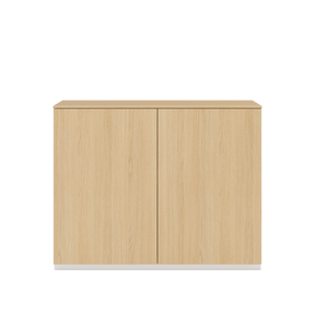 Vor weißem Hintergrund sieht man ein Sideboard aus Eichenholz mit zwei Drehtüren. Auf dem Schrank ist eine Abdeckplatte aus Eichenholz angebracht.